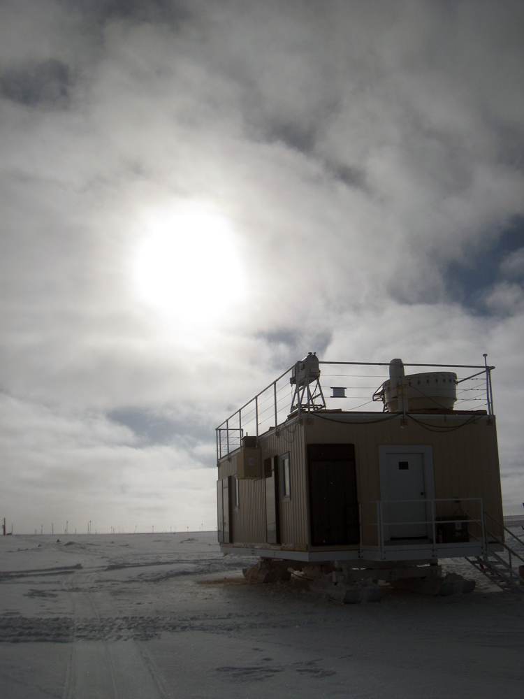 Photo of the ICECAPS Mobile Science Facility at Summit Station against a backdrop of Arctic clouds